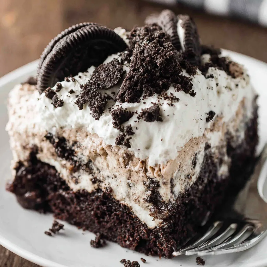 Sliced Oreo poke cake on a serving plate