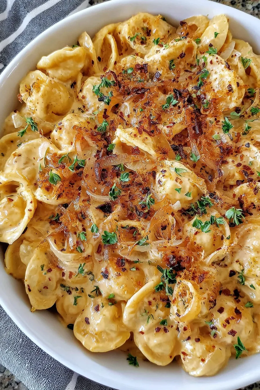 Creamy French onion pasta with melted cheese in pot