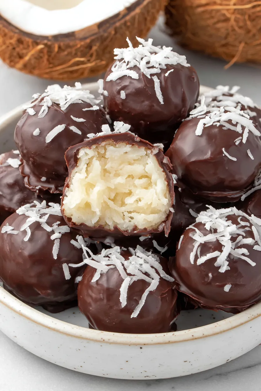 Coconut chocolate balls being dipped in chocolate