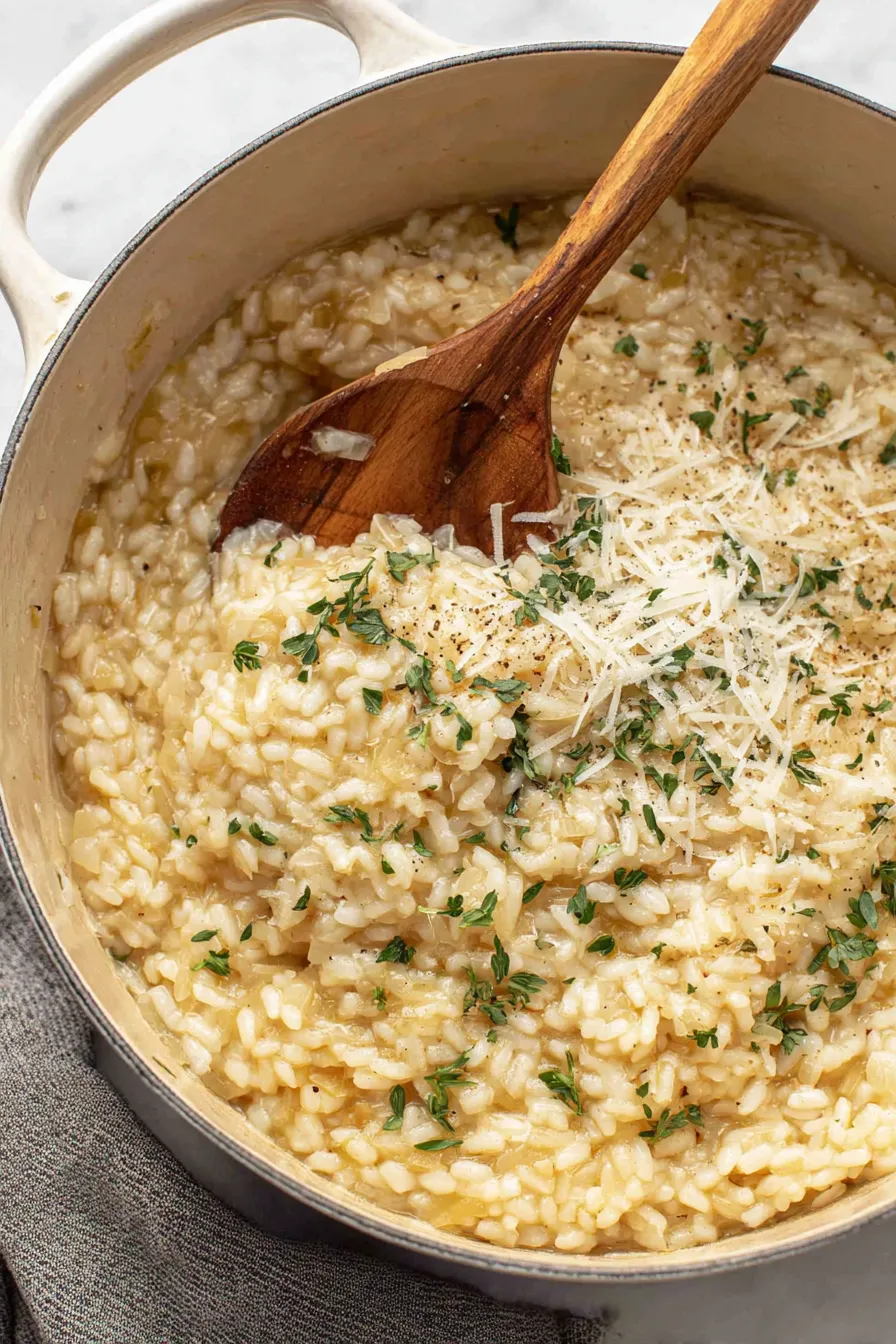 Creamy risotto in a shallow bowl topped with grated Parmesan and parsley