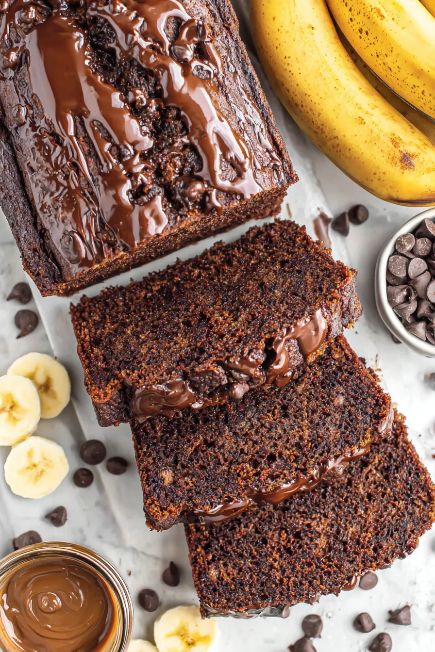 Sliced chocolate banana bread on a wooden board
