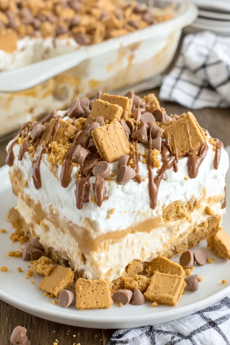 Layered peanut butter dessert in a glass dish showing cookie crust and creamy layers