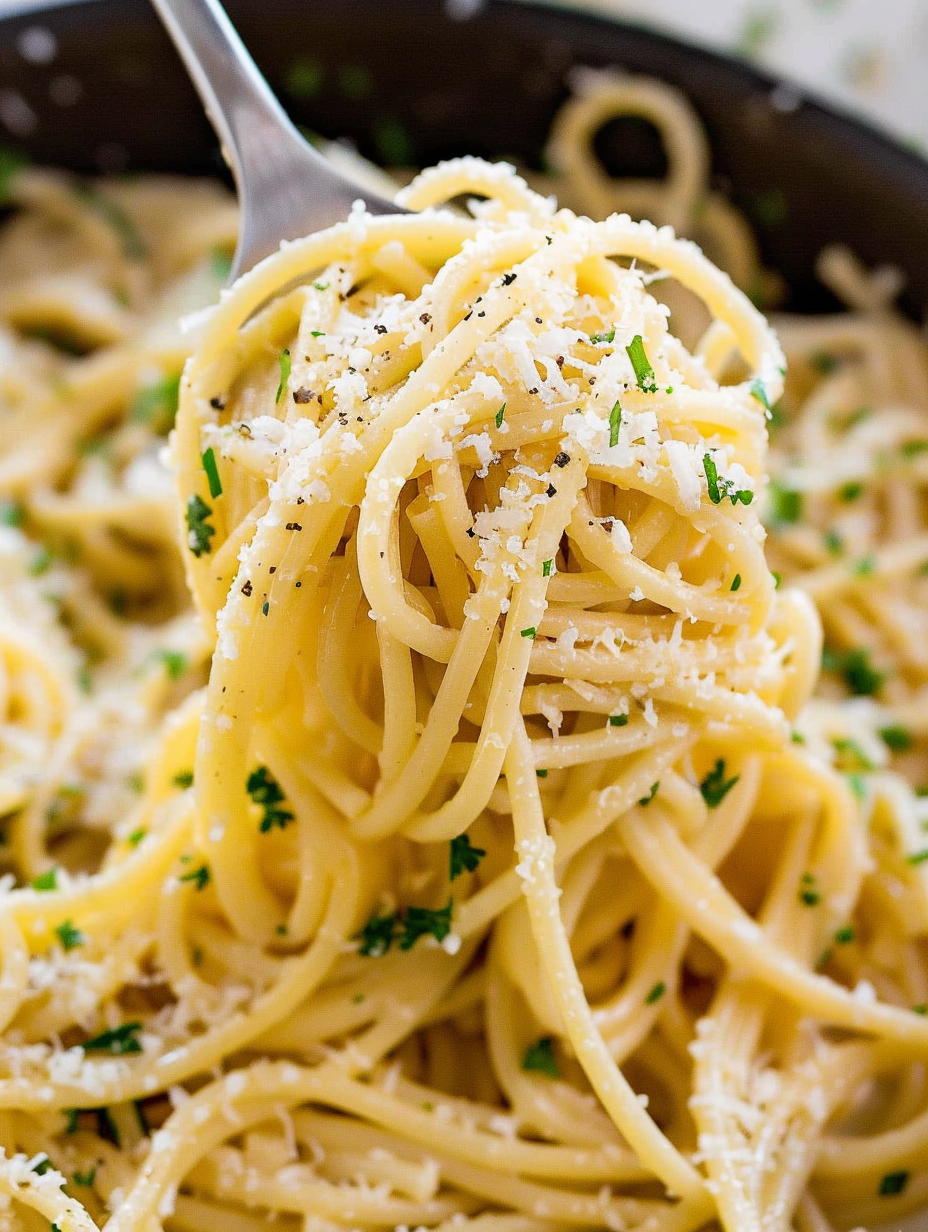 Plated garlic butter noodles garnished with parsley and Parmesan