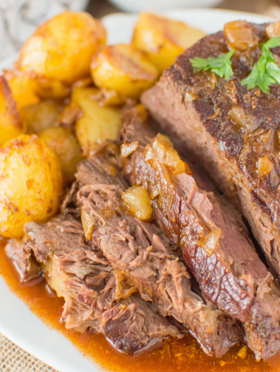 Plated slices of slow cooker roast with potatoes and carrots
