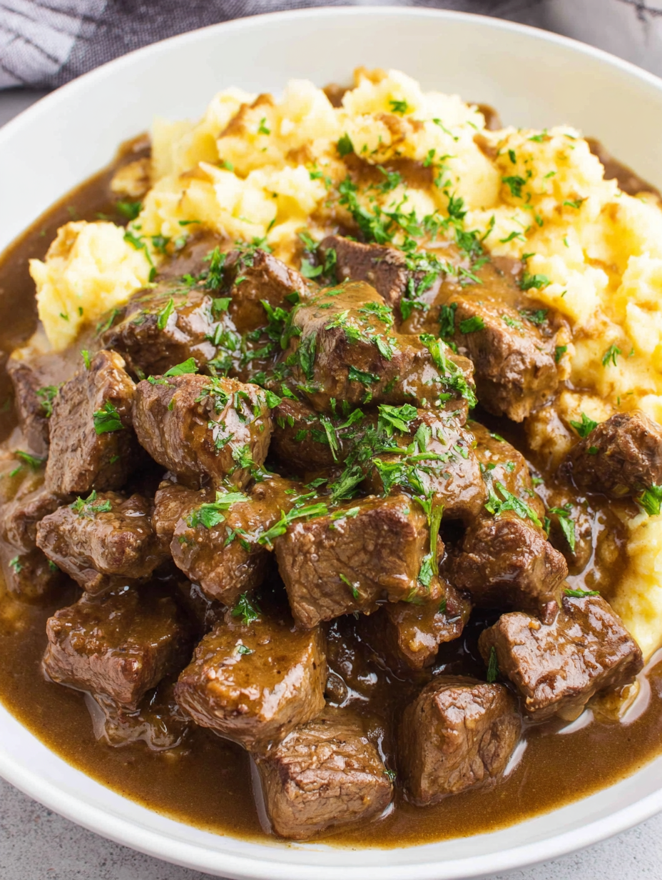 Spoon lifting beef tips with gravy