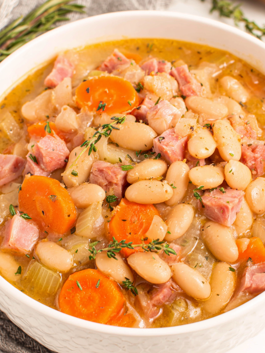 Bowl of creamy white bean and ham soup served with bread