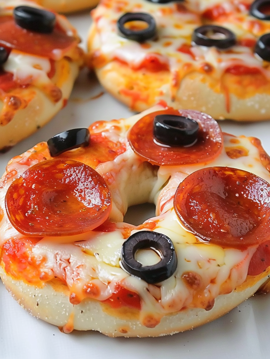 Topped pizza bagels on a cutting board