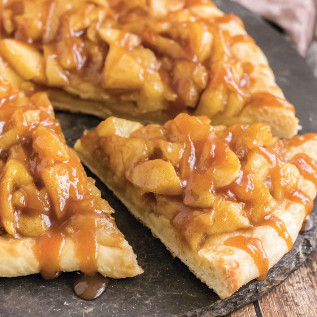 Caramel apple dessert pizza sliced on a pan
