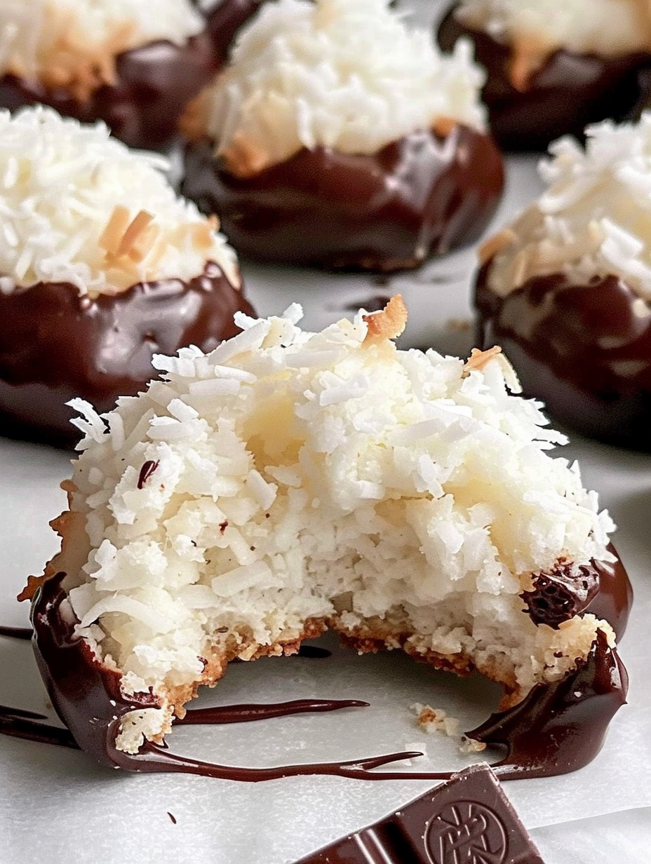 Chocolate dipped coconut macaroons cooling on parchment