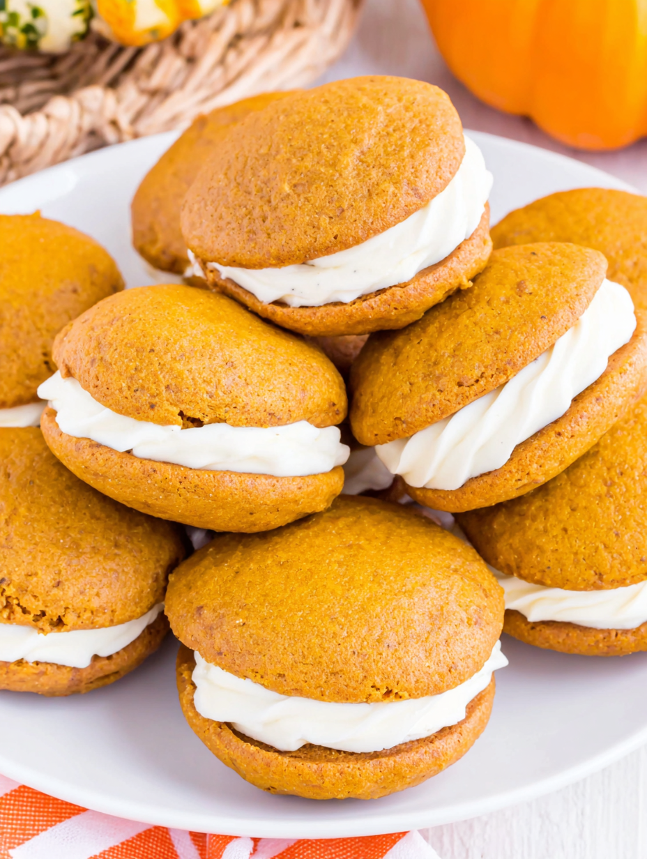 Two pumpkin whoopie pies on parchment