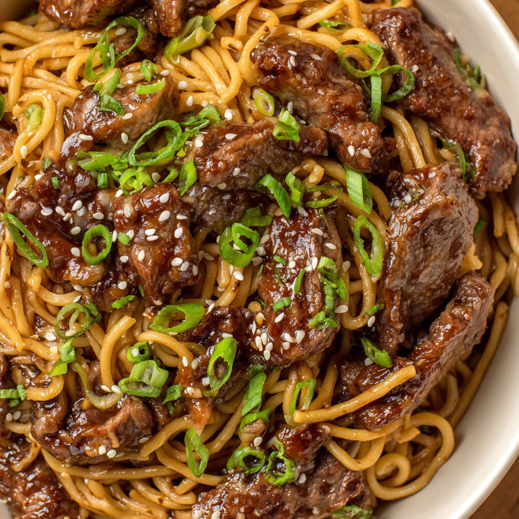 Close-up of noodles twirled on a fork with seared beef and scallions