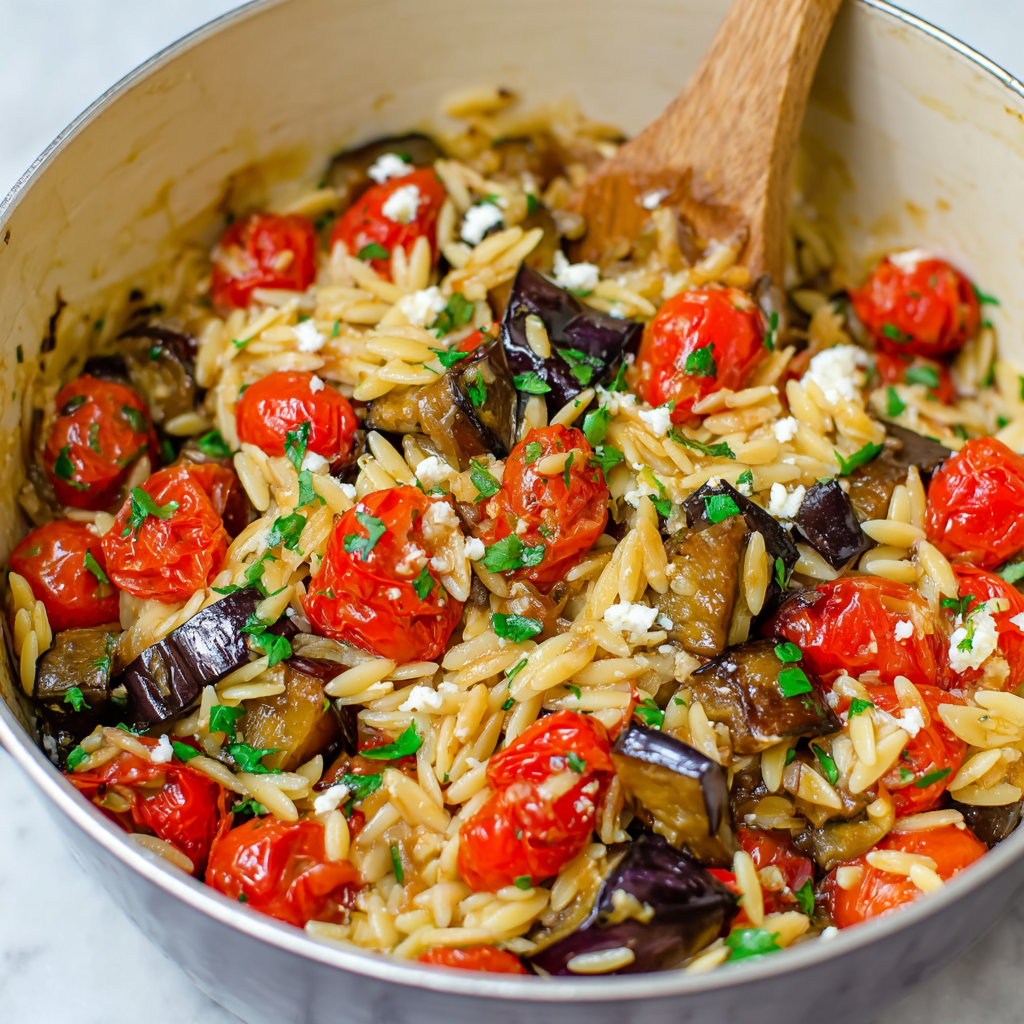 Close-up of orzo pasta mixed with roasted vegetables, feta, and herbs