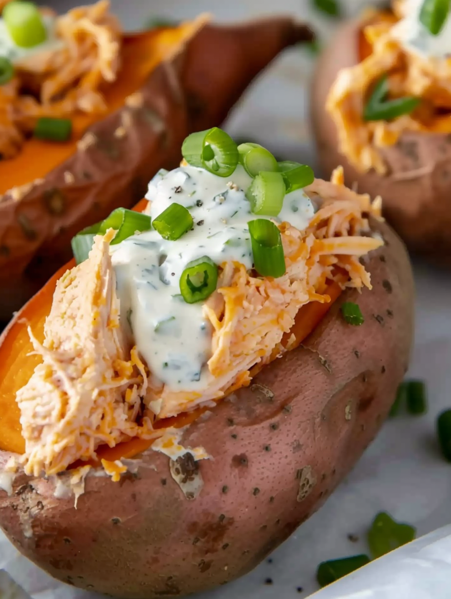 Sweet potatoes stuffed with buffalo chicken and ranch on a serving plate