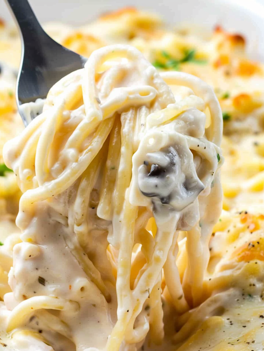 Baked chicken tetrazzini in a 9x13 dish topped with melted cheese and parsley