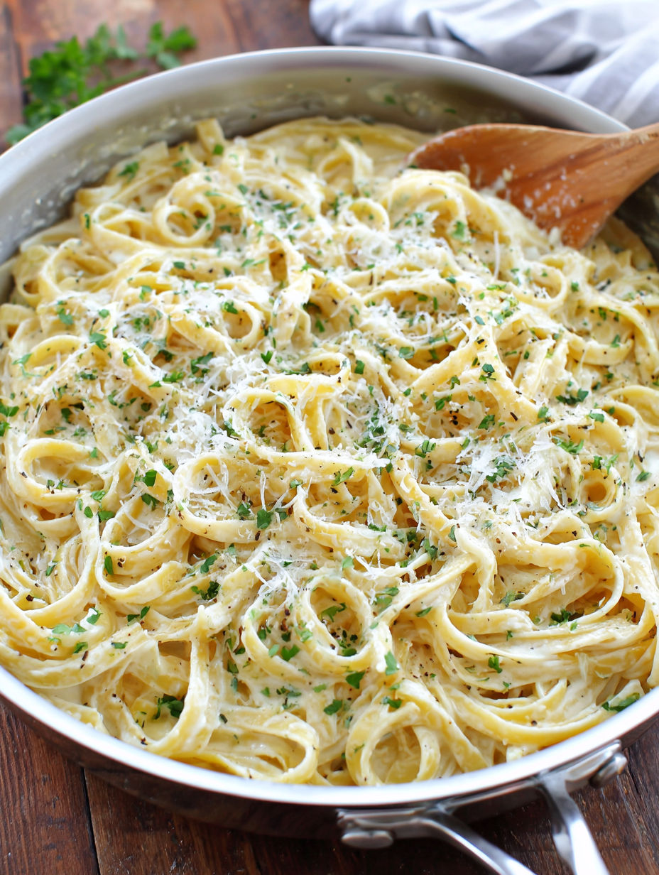 Creamy pasta being served with parsley garnish