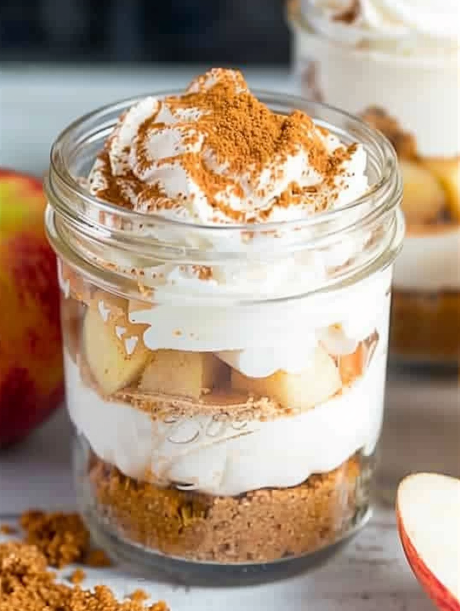 Apple pie cheesecake jars with layered filling and apples