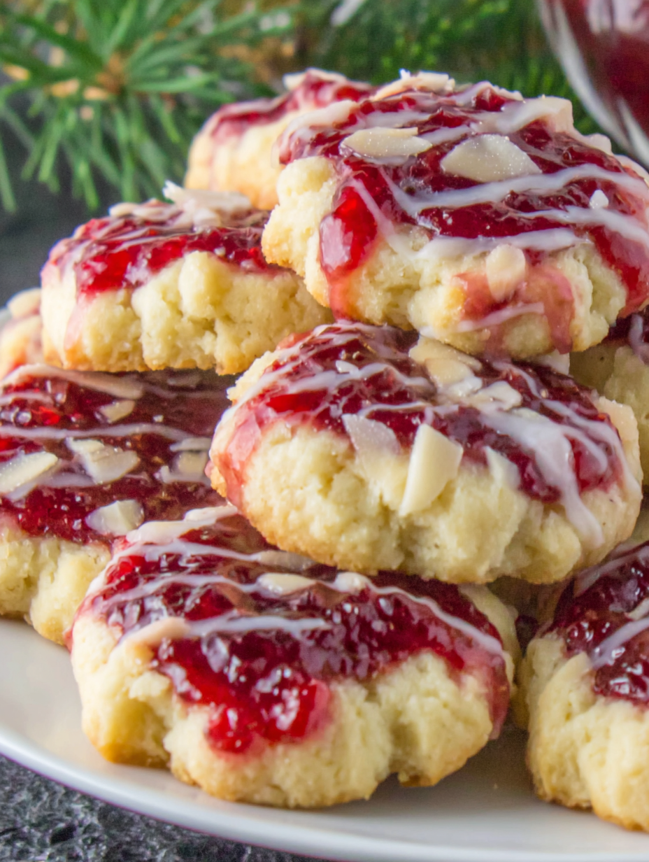 Close up of glazed thumbprint cookie with raspberry jam