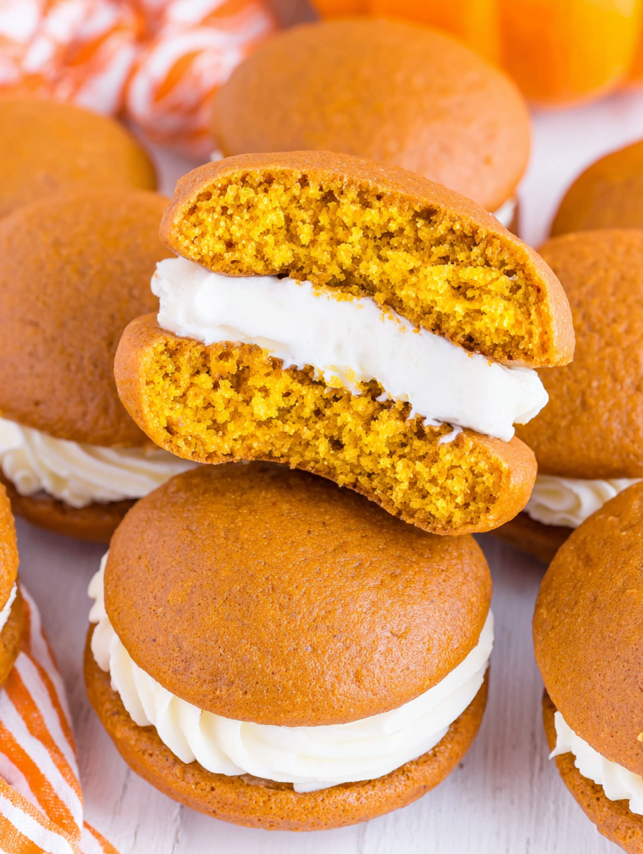 Two pumpkin whoopie pie cookies on a cooling rack