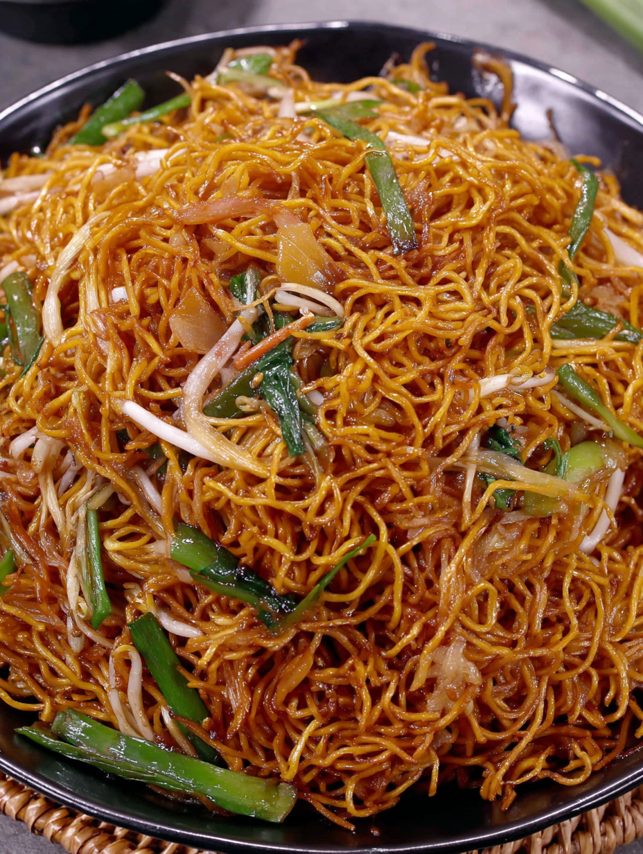 Crispy Cantonese chow mein in wok with scallions