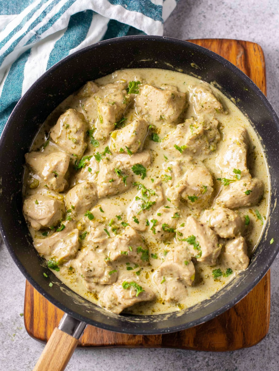 Malai Chicken Curry in a white bowl garnished with kasoori methi