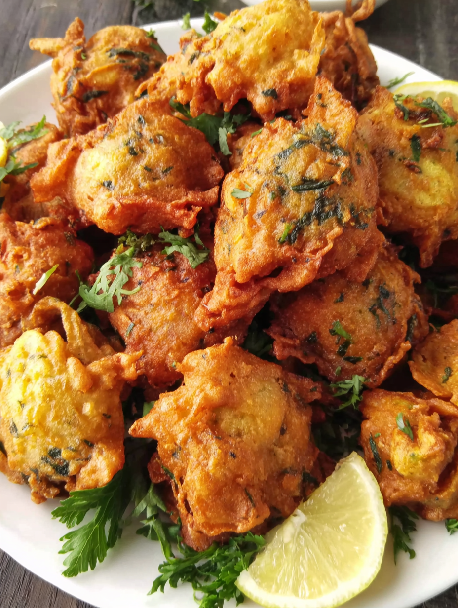 Golden chicken pakoras on a platter with chutney