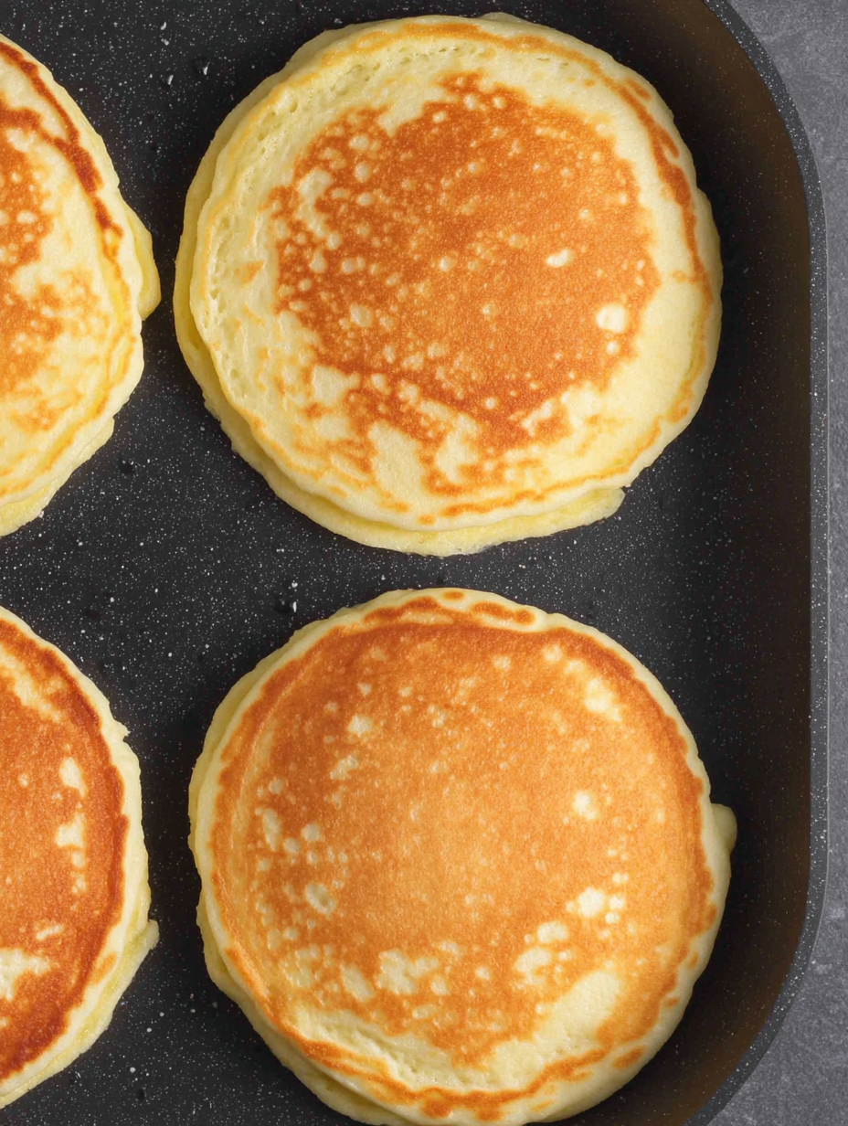 Fluffy pancakes stacked on a plate with syrup