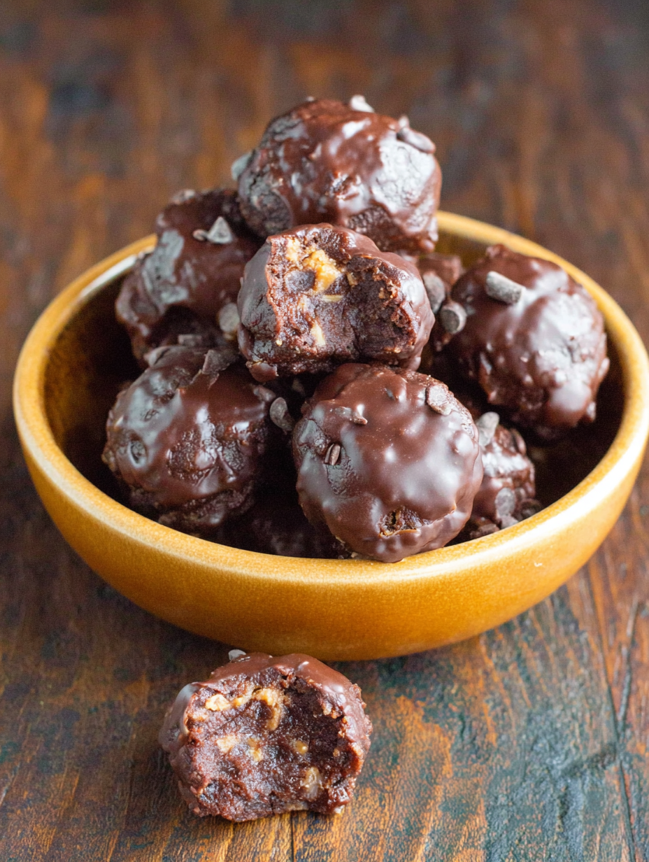 No bake brownie bites on a plate with cocoa dusting