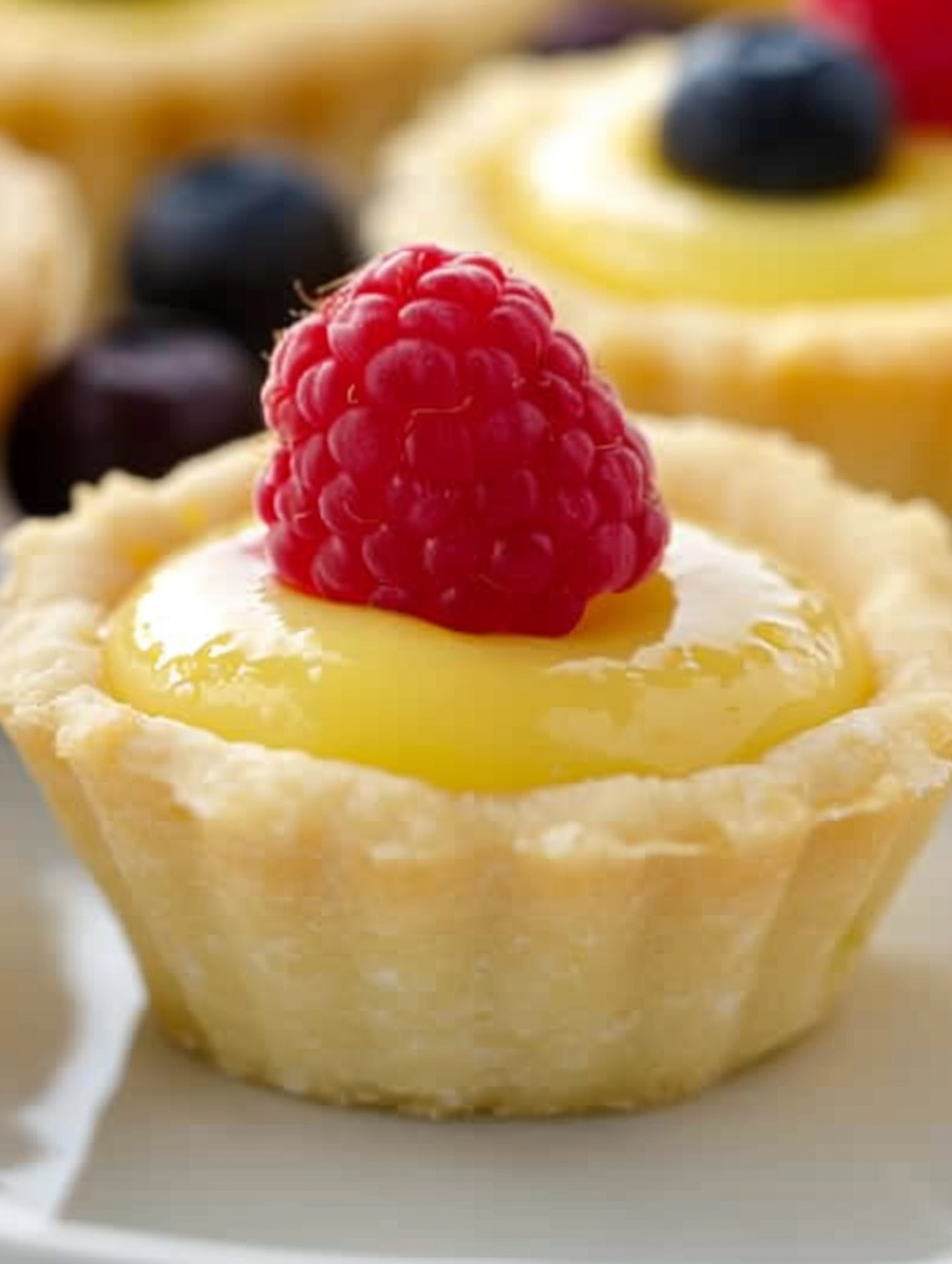 Lemon curd being spooned into cookie cups