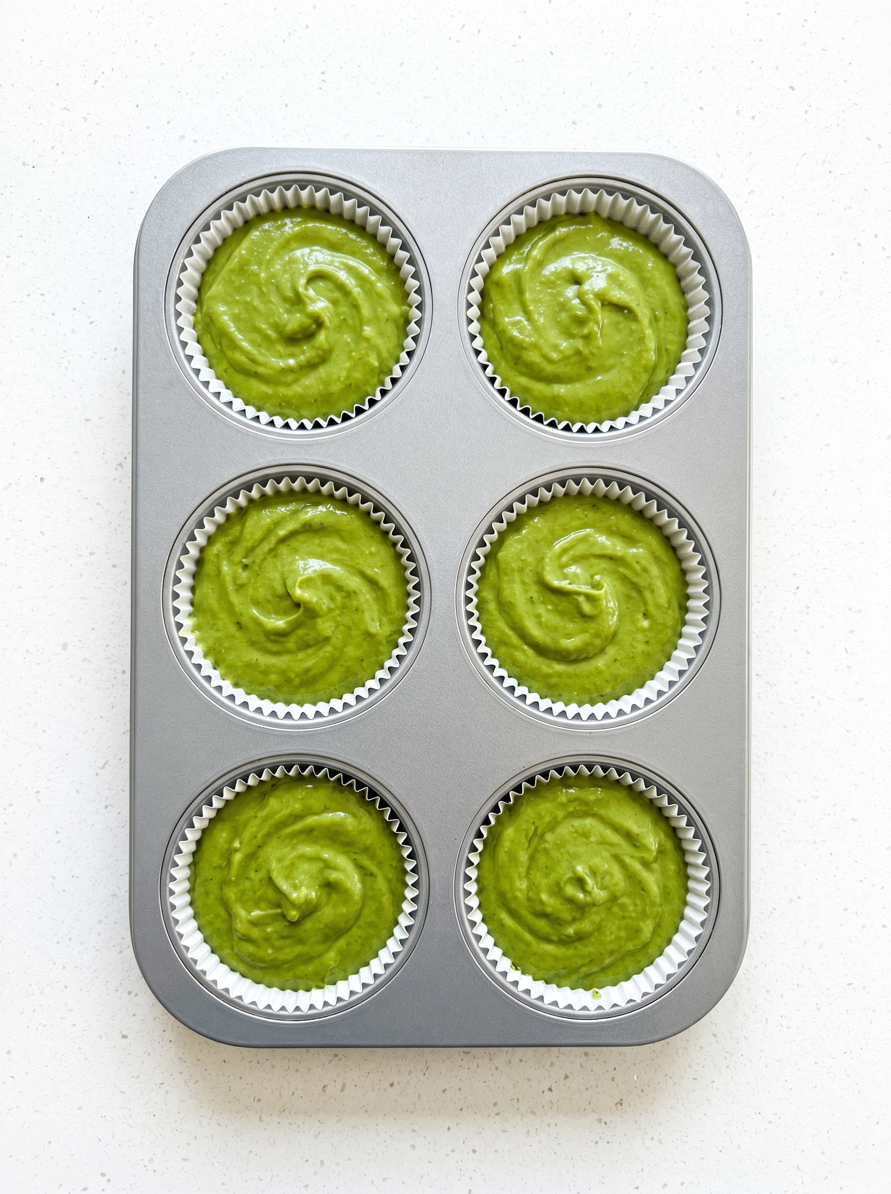 Freshly baked matcha muffins cooling on a wire rack