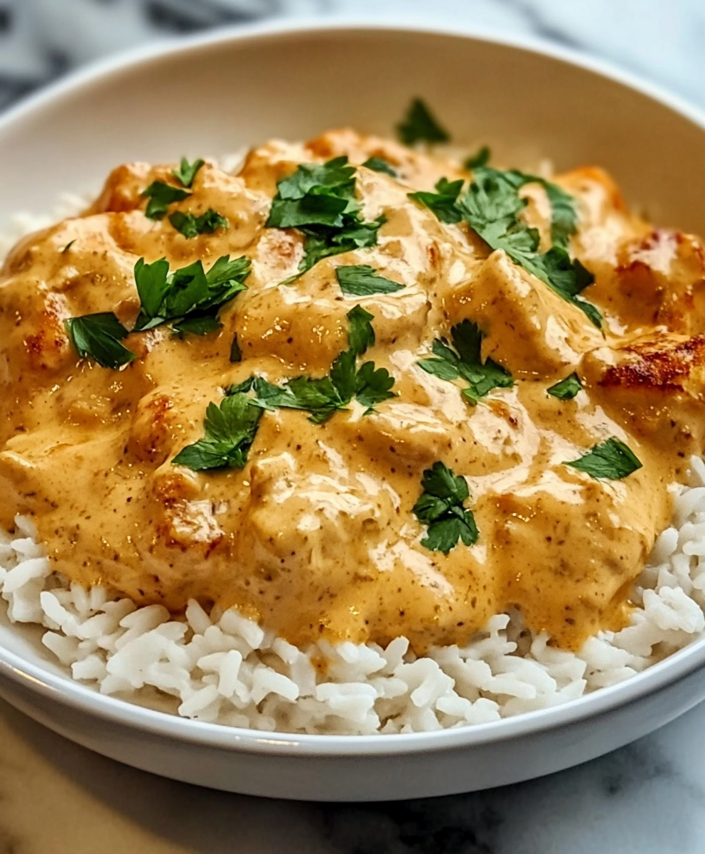 Plated smothered chicken served with rice and parsley