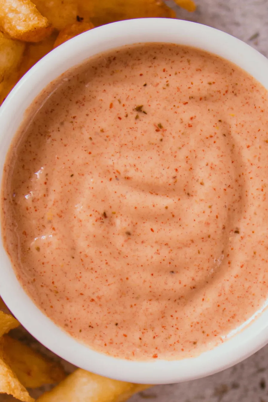 Creamy fry sauce in a small jar with fries