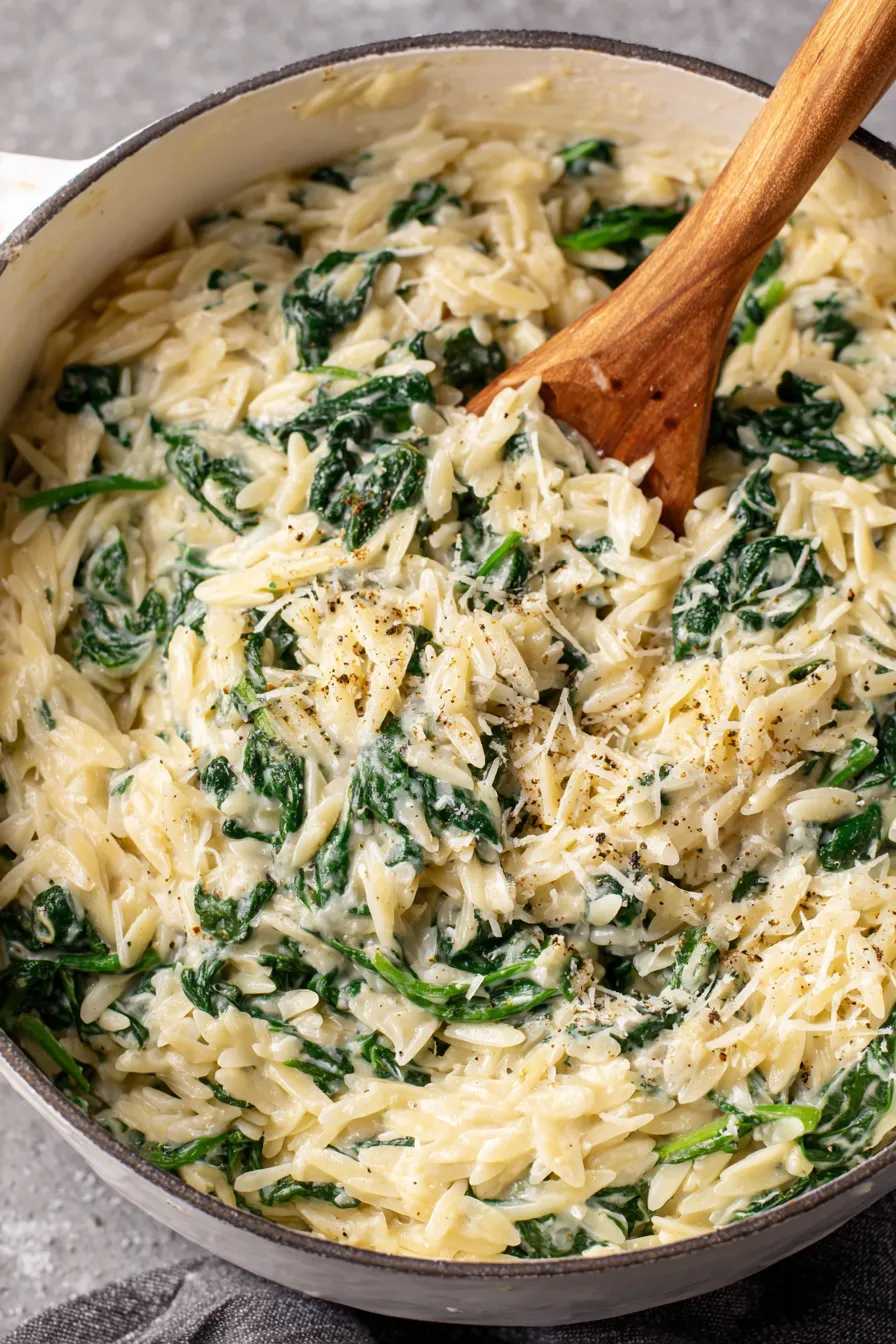 Creamy garlic spinach orzo in a white bowl