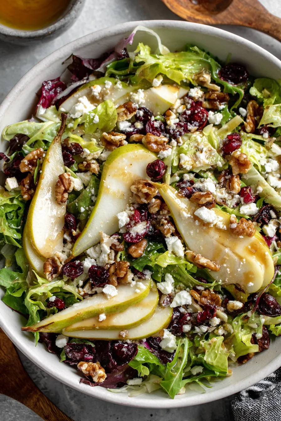 Close up of sliced pear and greens in a bowl