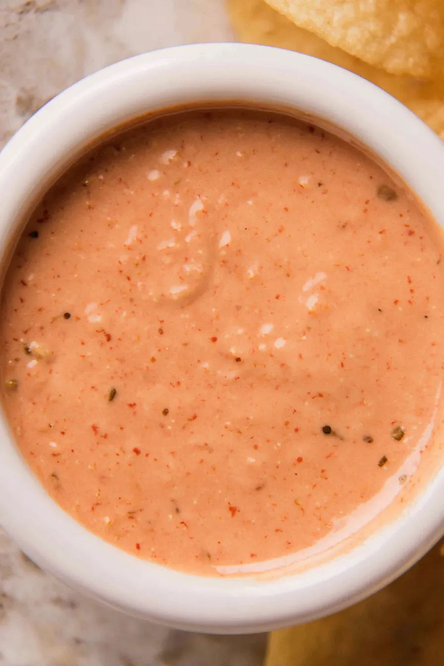 Jar of fry sauce on a wooden board with condiments