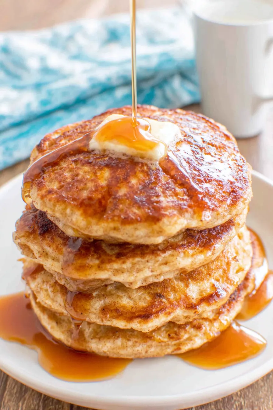 Stack of apple pancakes with syrup being poured
