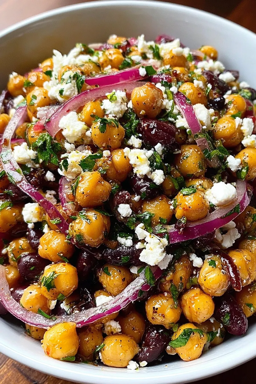 Chickpea and black bean salad in a bowl with feta and parsley