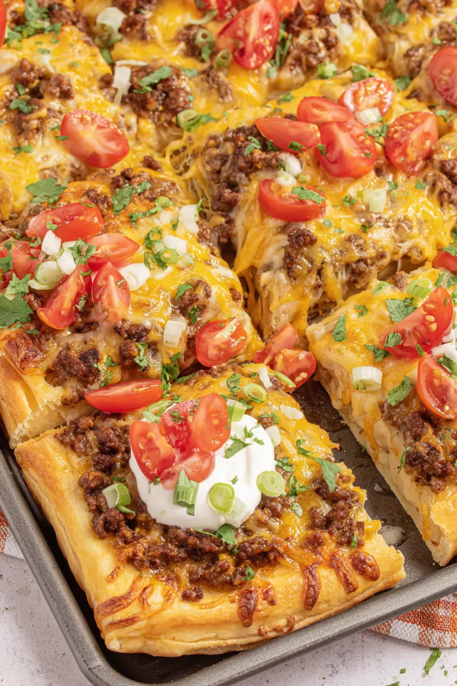 Taco pizza with melted cheese on baking sheet