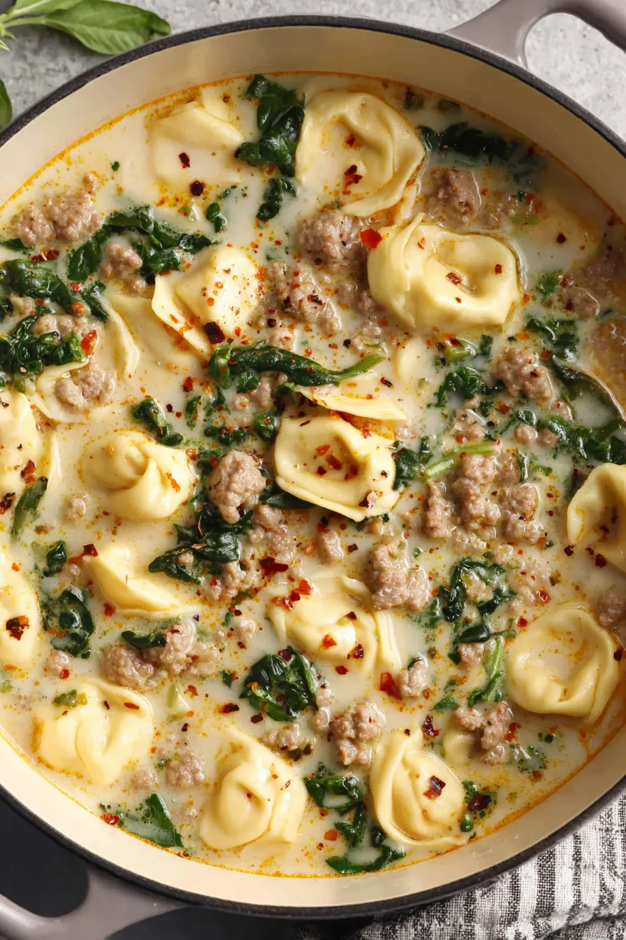 Bowl of sausage tortellini soup with kale and Parmesan