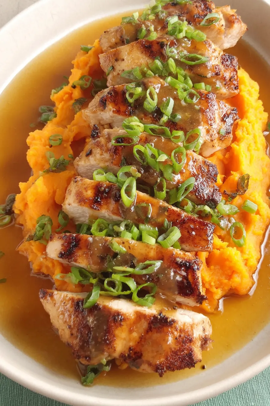 Plated maple-glazed chicken with mashed sweet potatoes and green onions