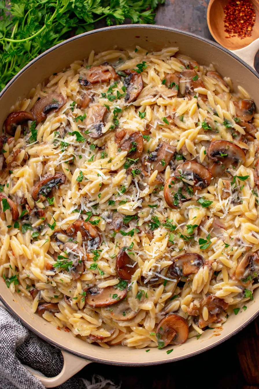 Creamy mushroom orzo finished in a serving bowl topped with parsley