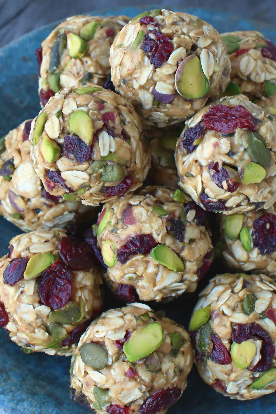 Energy bites on a plate with cranberries and pistachios