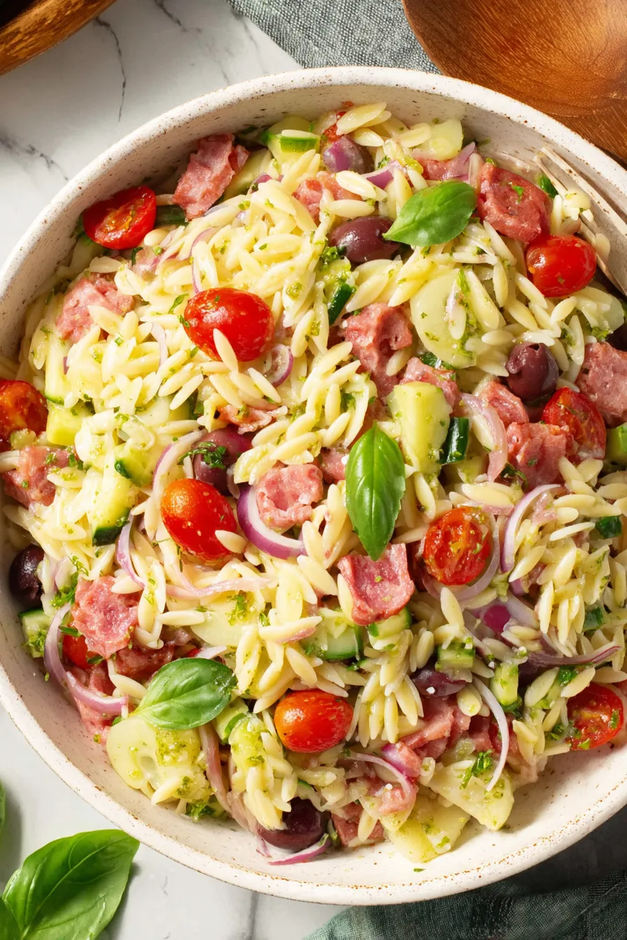 Italian orzo salad in a bowl with tomatoes and olives