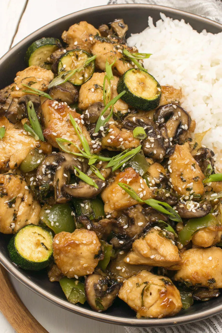 Plated mushroom chicken with sesame seeds and green onion garnish
