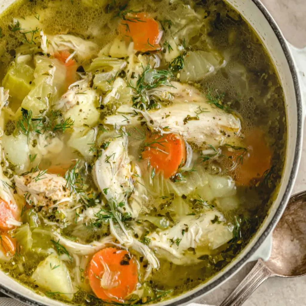Warm bowls of chicken soup garnished with fresh herbs