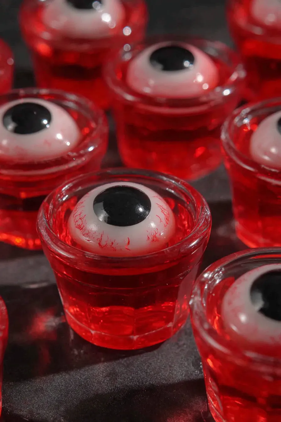 Red gelatin shots with candy eyeballs set in small glasses