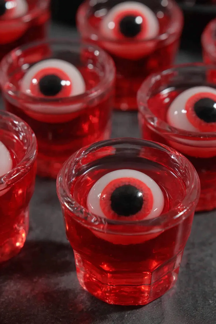 Close up of a single red jello shot with a candy eye on top