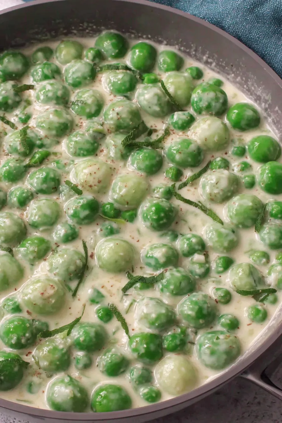 Creamed peas cooking in a skillet