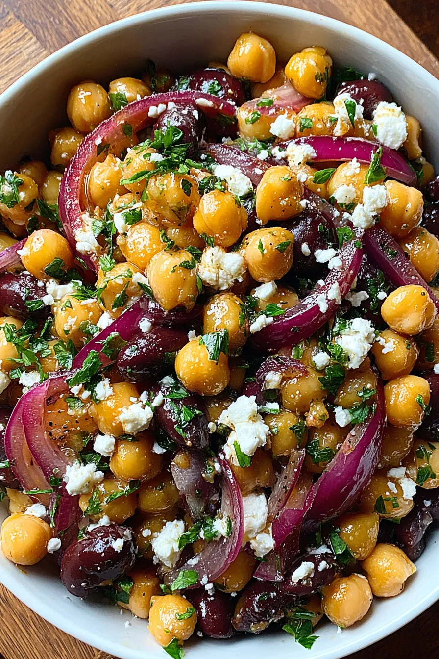 Close-up of tossed bean salad with feta and parsley