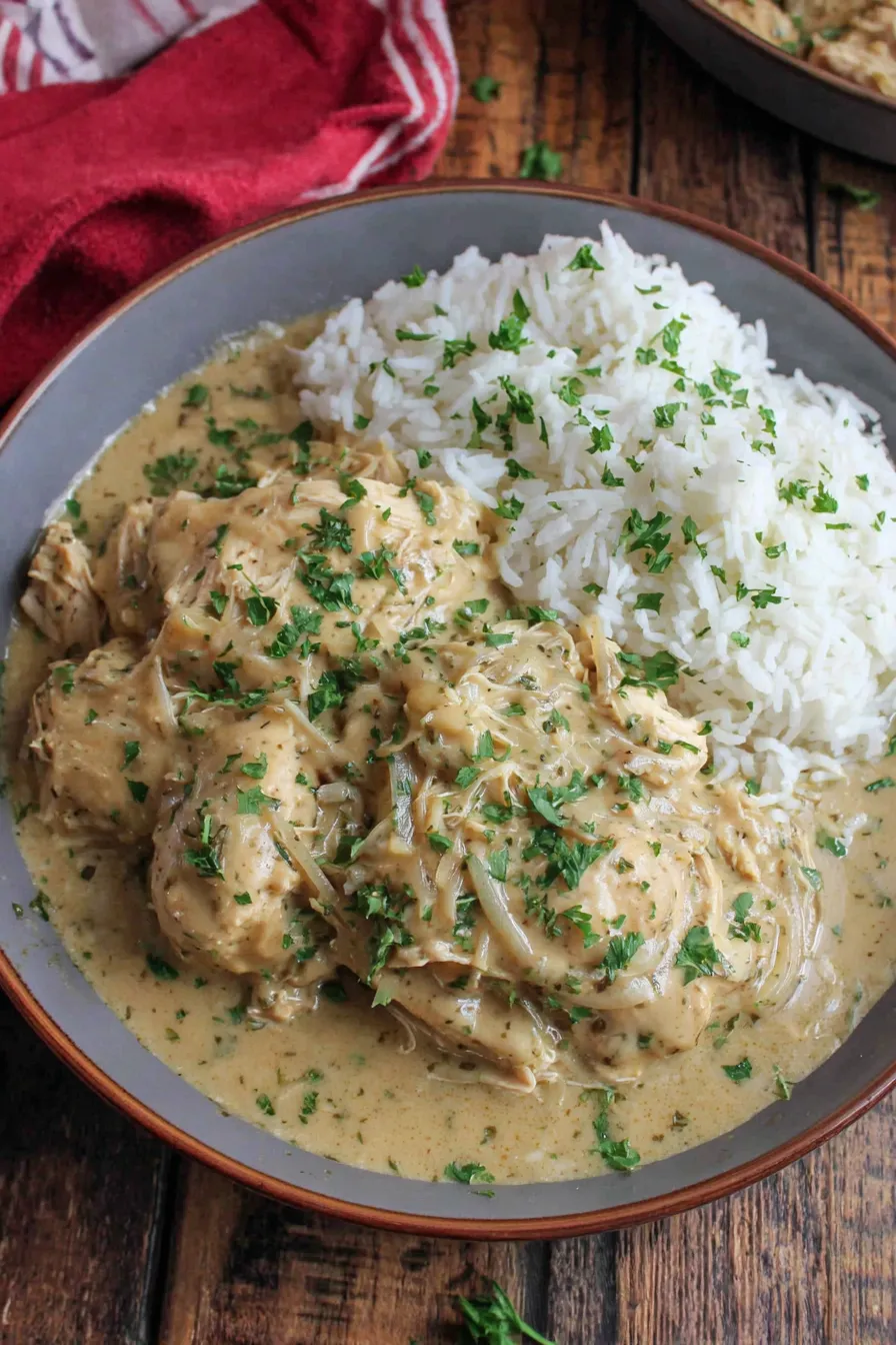 Plated chicken and gravy over mashed potatoes garnished with parsley
