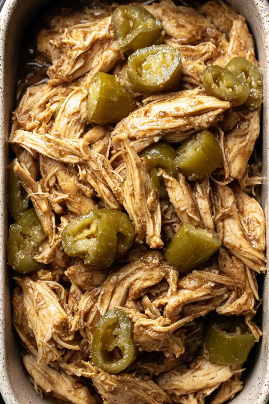 Pepperoncini and shredded Mississippi chicken in a slow cooker
